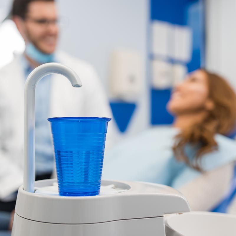Patient at dentist taking glass of water